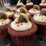 red velvet cupcakes with cream cheese frosting with a Hershey kiss acorn on top