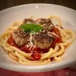 spaghetti and meatballs with sauce in a bowl