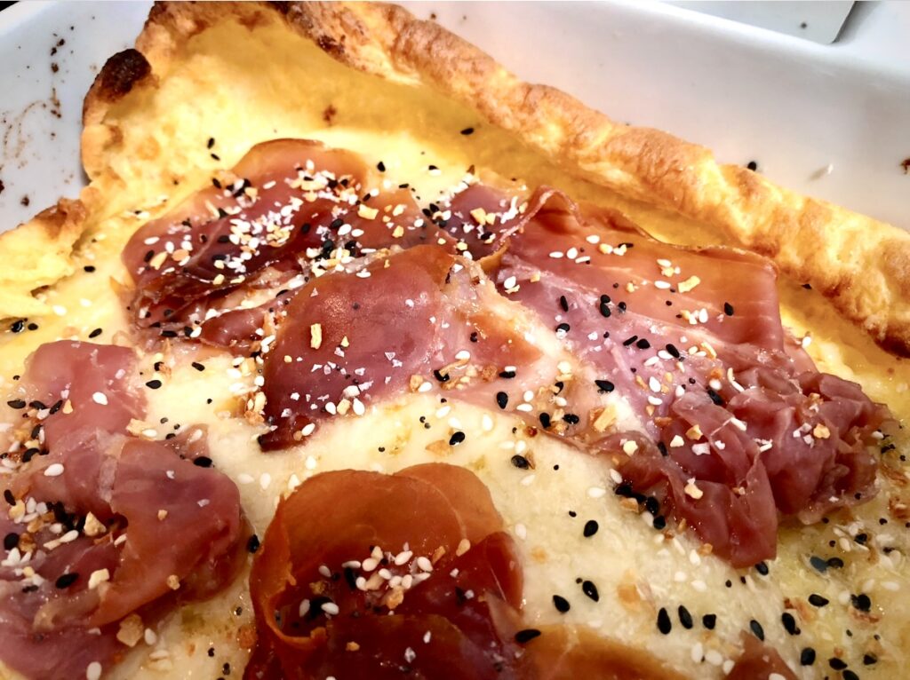 Close up of baked bismarck oven crepe with proscuitto and swiss